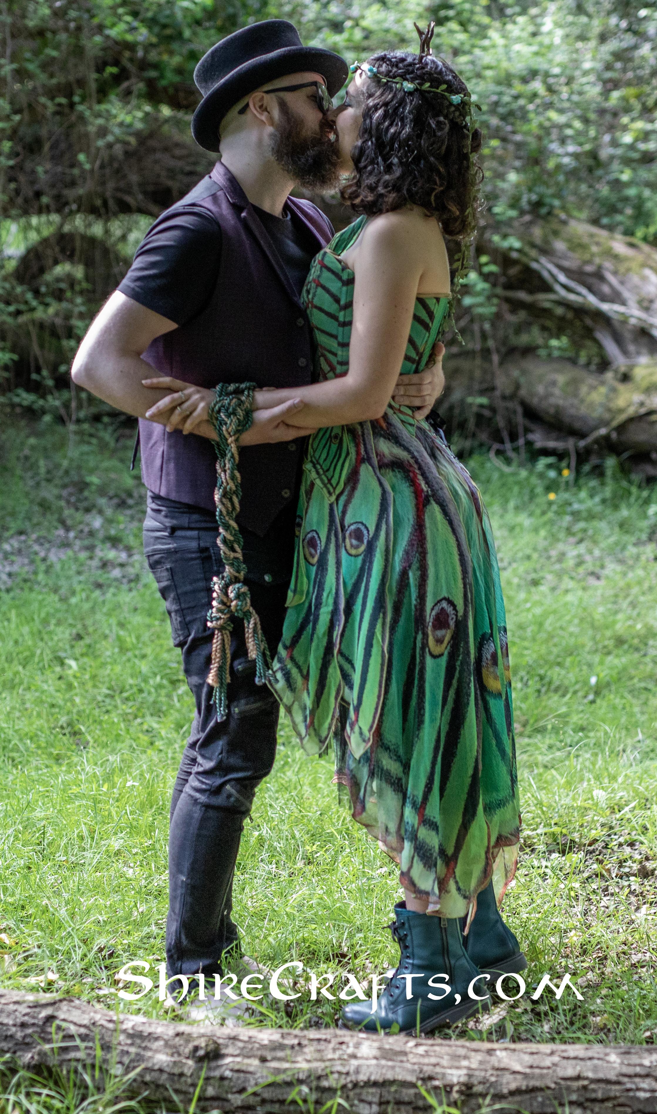 Patricia and Logi posing in the forest with their handfasting cord.