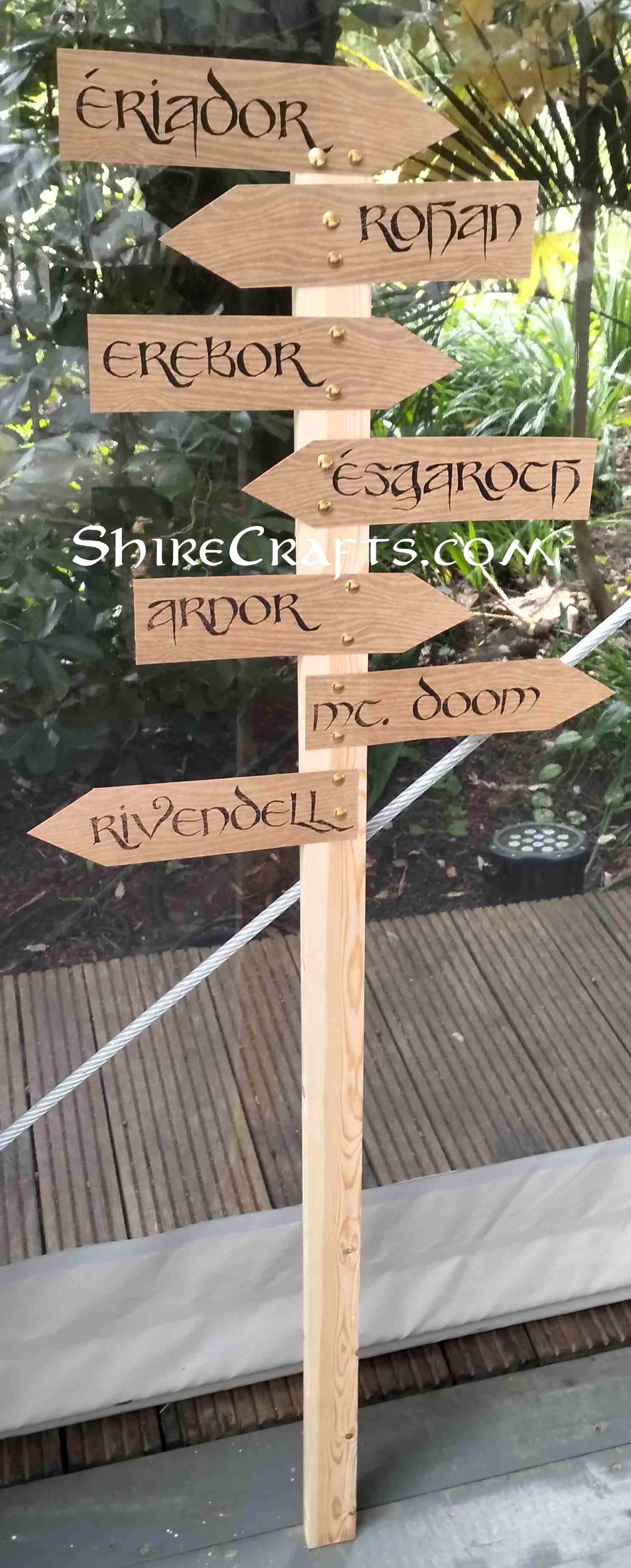 Picture of a wooden stick with paper signs in arrow shapes, containing middle-earth names.